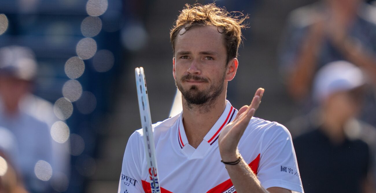 Daniil Medvedev claps on his racket.