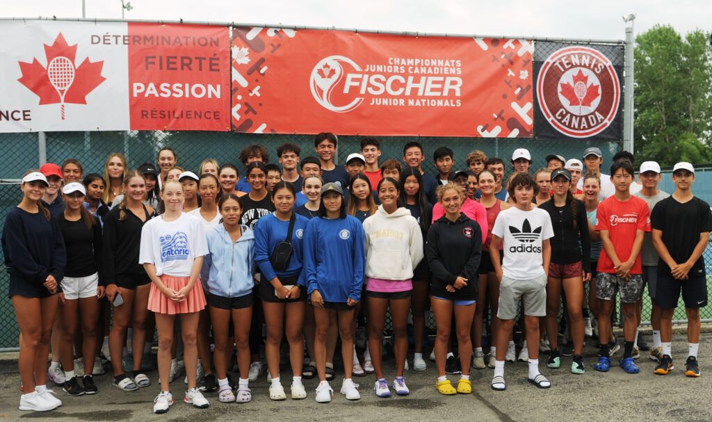 Players stand in front of a Junior Nationals sign.