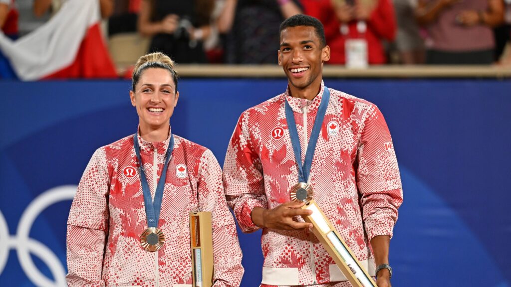 Gabriela Dabrowski and Felix Auger-Aliassime stand on the podium wearing their Olympic bronze medals and smile.