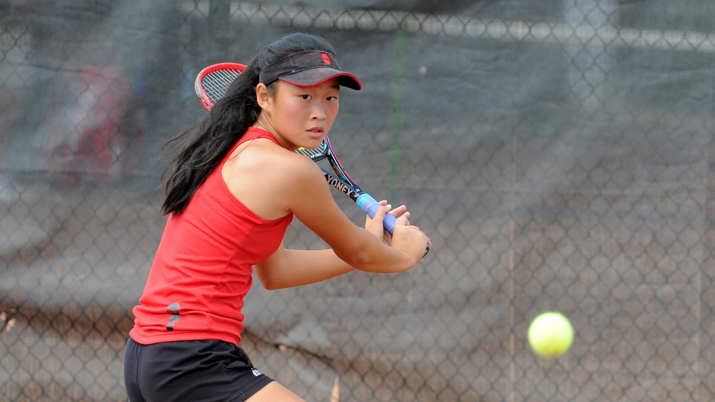 young girl returning serve