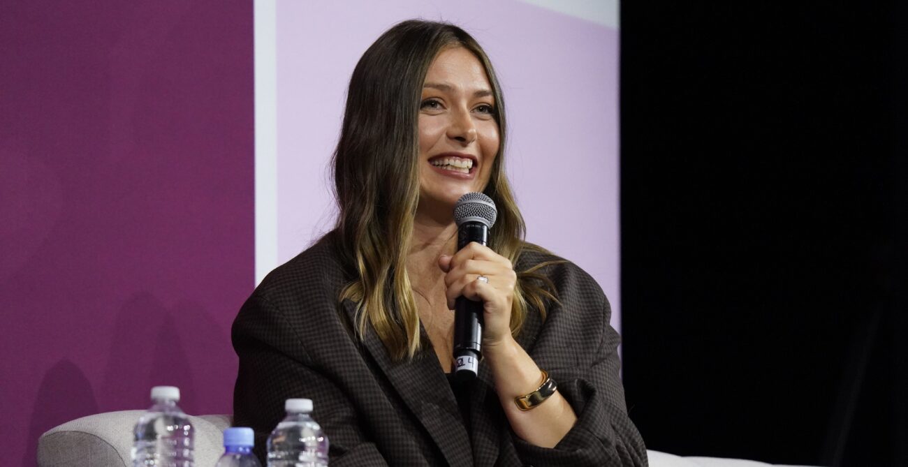 Maria Sharapova holds a microphone and smiles.