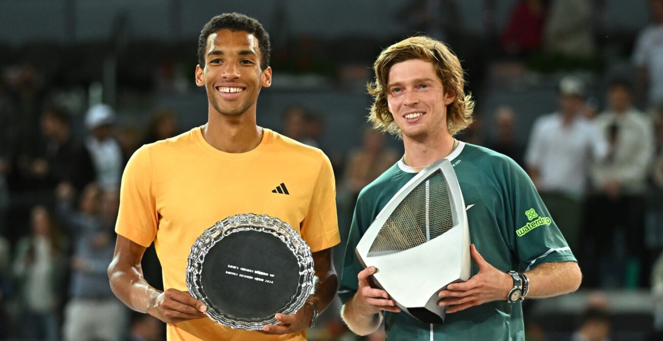 Felix Auger-Aliassime (left) holds up his runner-up trophy and smiles next to Andrey Rublev, holding his champions trophy in Madrid.