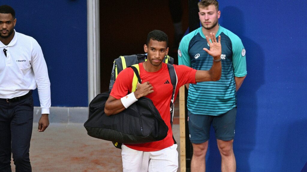 Felix Auger-Aliassime waves to the crowd as he walks on court at the Olympics. He lost in the bronze-medal match to Lorenzo Musetti.