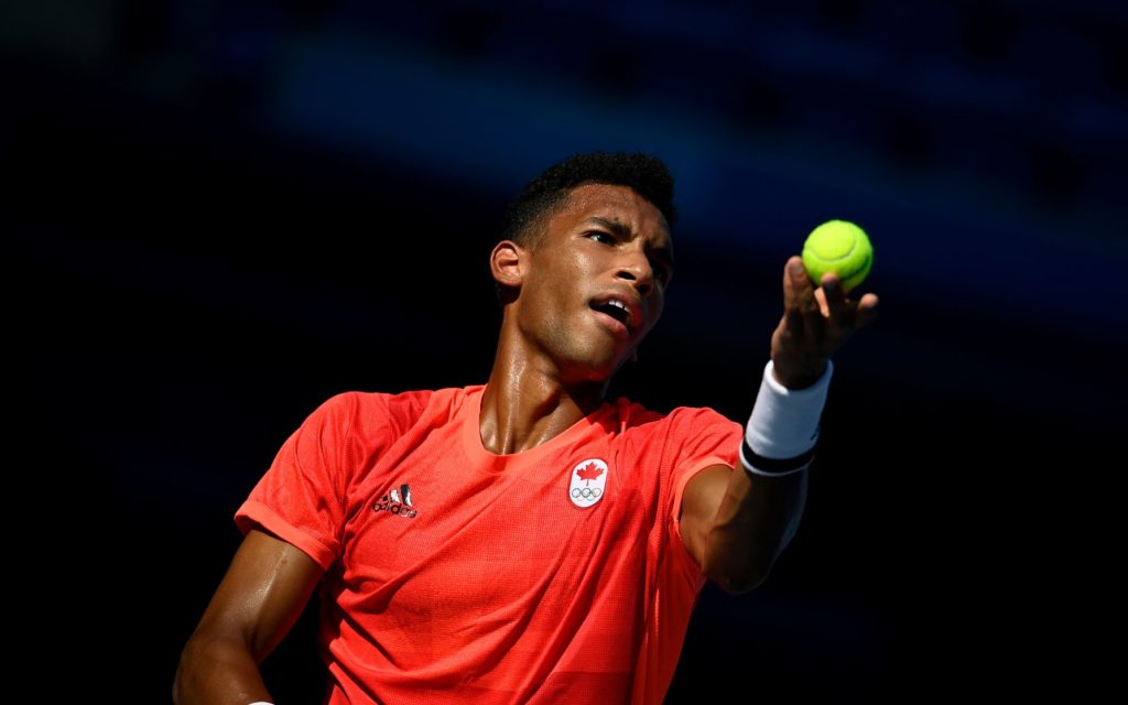 Félix Auger-Aliassime tosses the ball to serve.