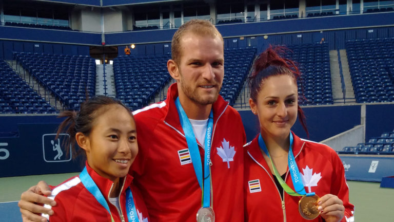 Tennis players wearing medals on court