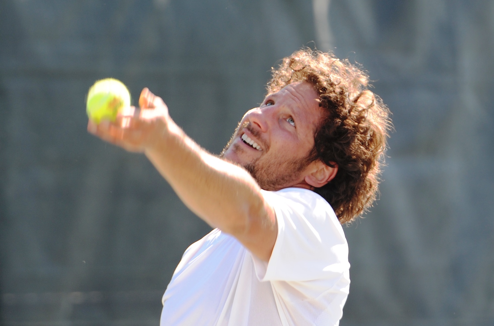 man serving tennis ball