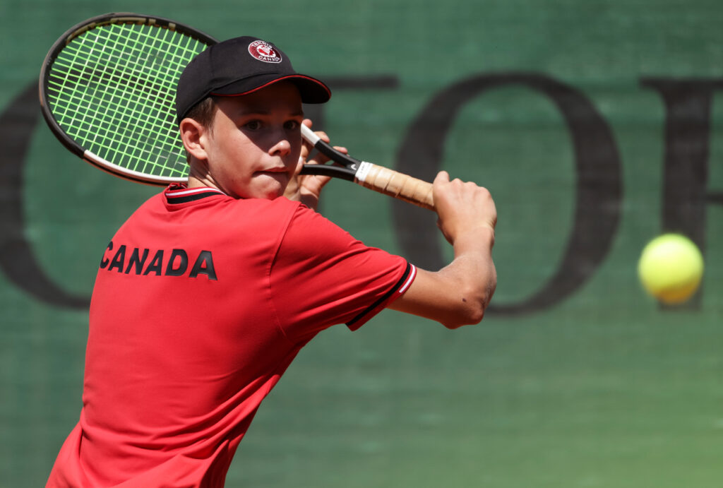 Callum MacKinnon backhands a ball at the ITF World Junior Tennis Finals